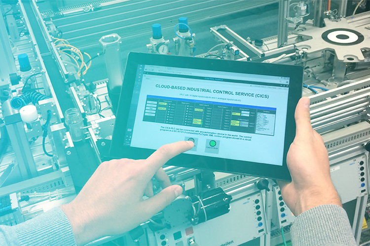 Tablet zur Steuerung einer Produktionsanlage in der Cloud Tablet vor einer Modellfabrik
